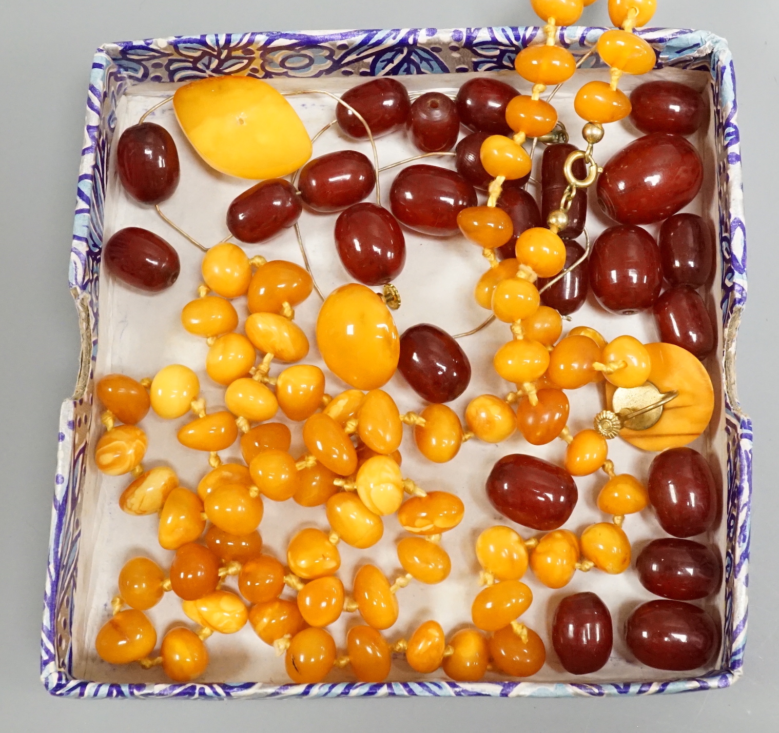 A single strand amber necklace, par of amber earrings and an amber pendant?(lacking fitting), gross weight 40 grams, together with a small quantity of loose simulated cherry amber beads.